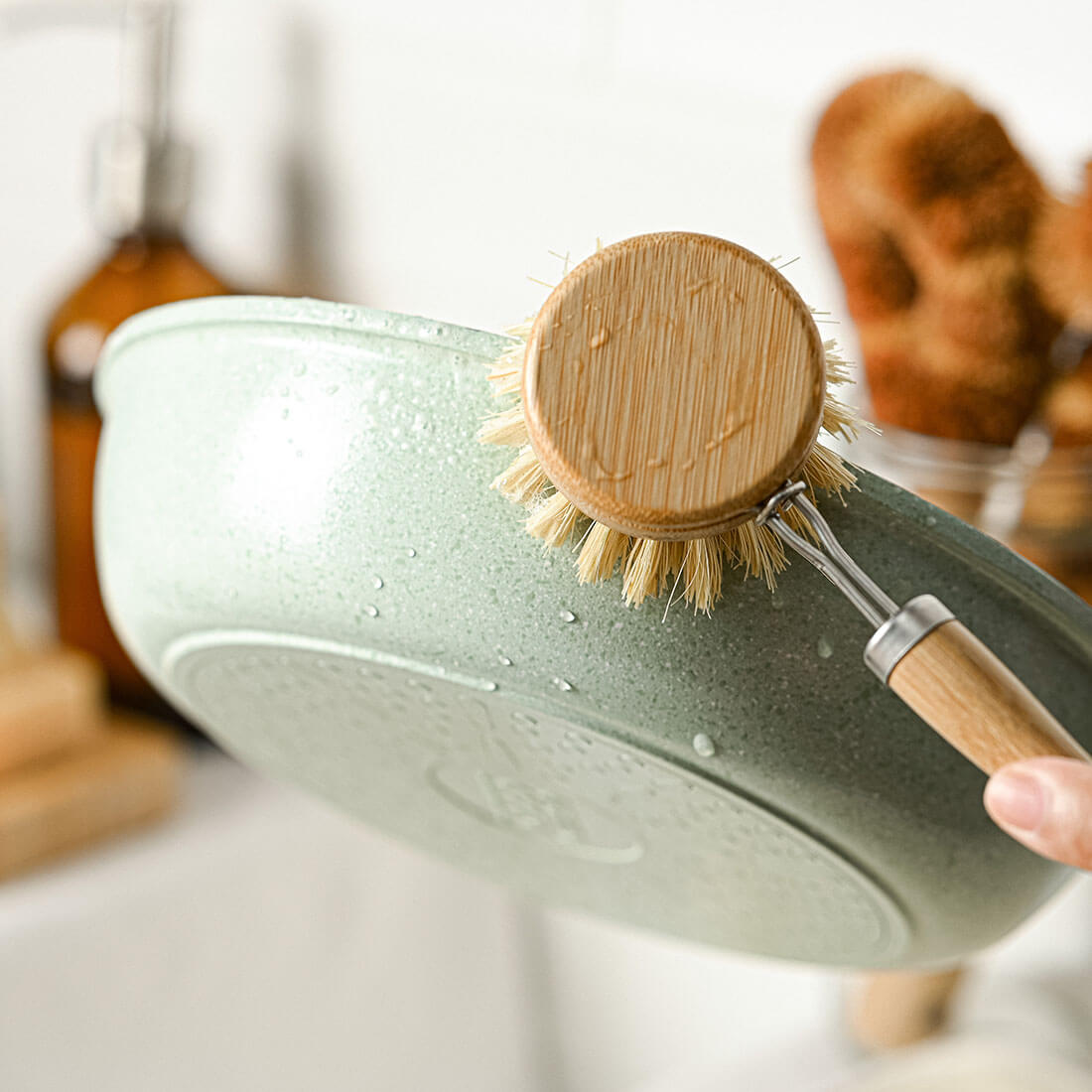 Bamboo dish brush cleaning mint green pan, perfect for van life kitchen essentials