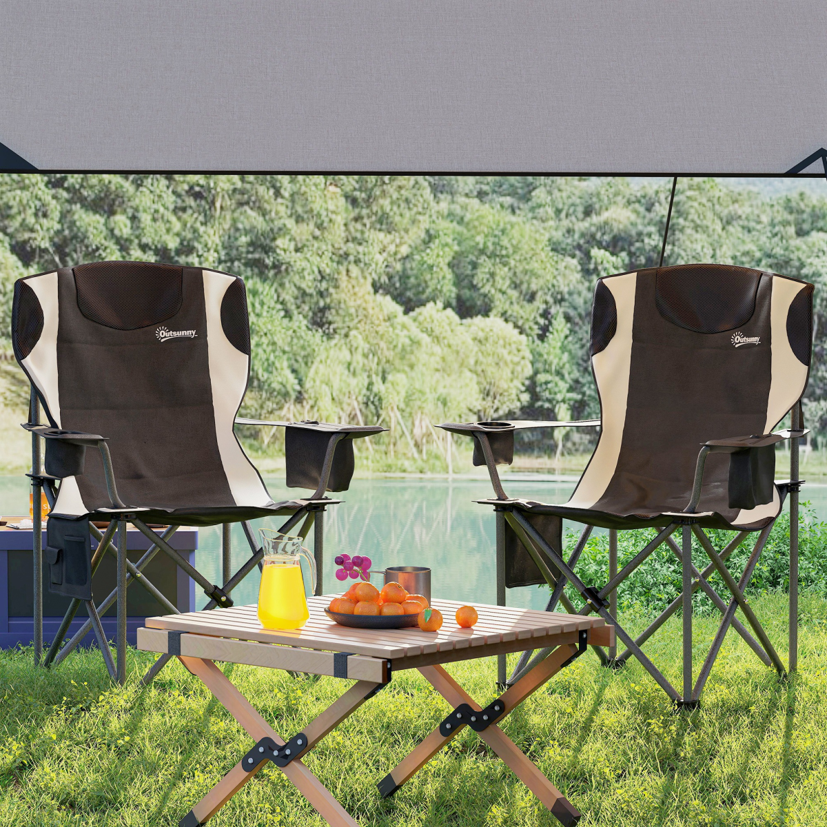 Two brown and cream camping chairs with cup holders under awning, beside foldable table with juice and oranges, ideal for van life and outdoor adventures.