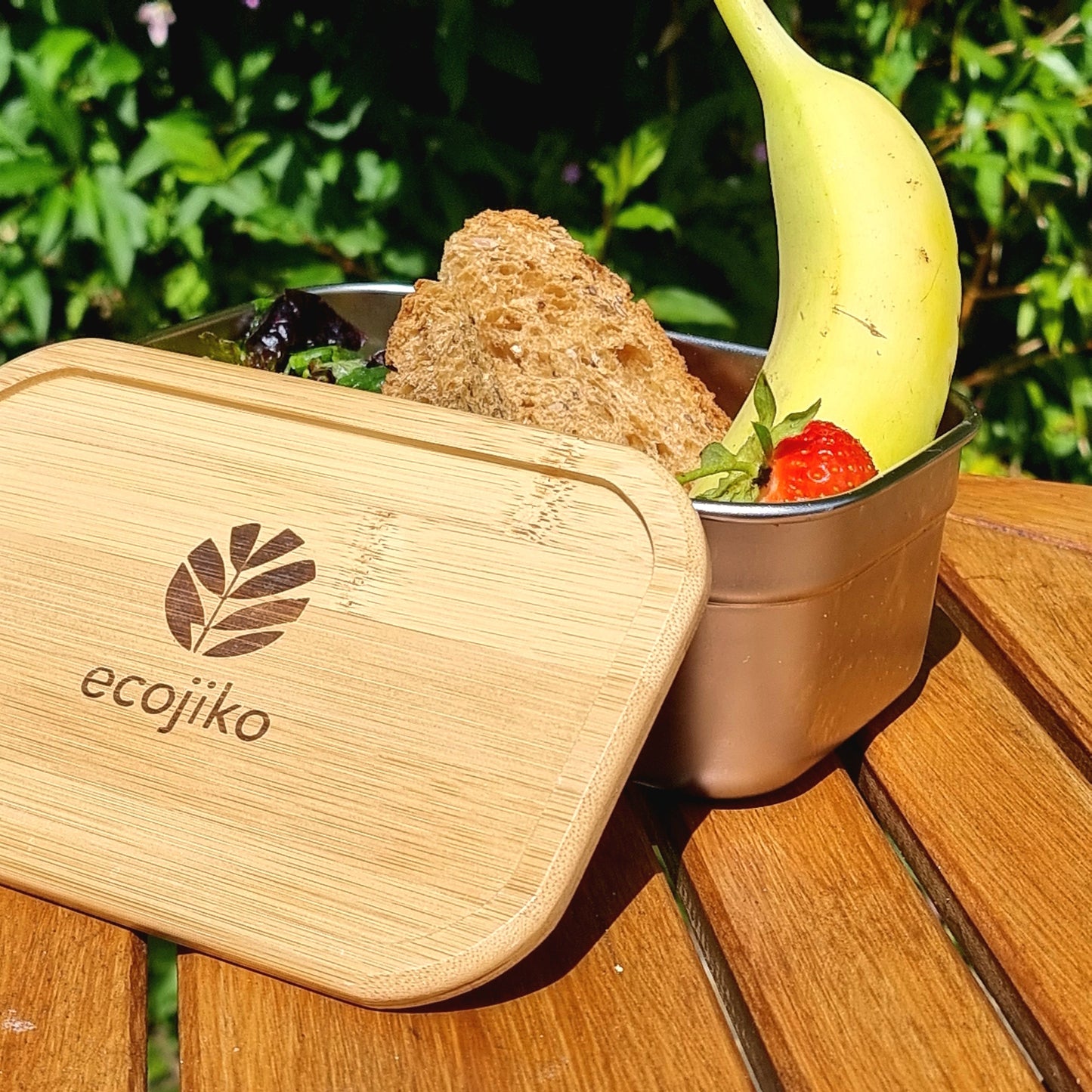Ecojiko bamboo lunch box with salad, bread, banana & strawberry for van life adventures outdoors