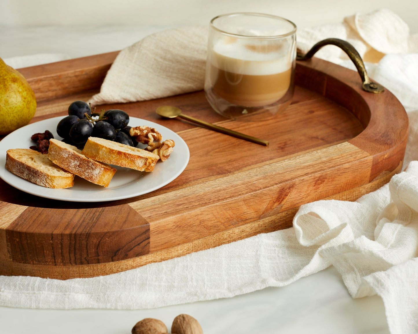 Wooden serving tray with coffee, grapes, bread, and walnuts for van life breakfast essentials