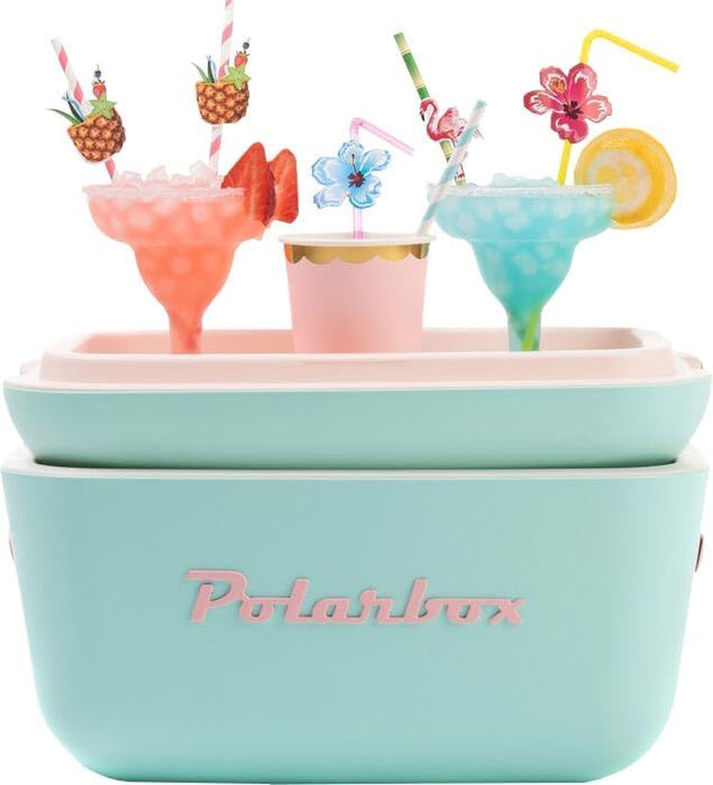 A pastel teal cooler with pink lettering topped by three colourful cocktail glasses and a paper cup, all with decorative straws and fruit garnishes.