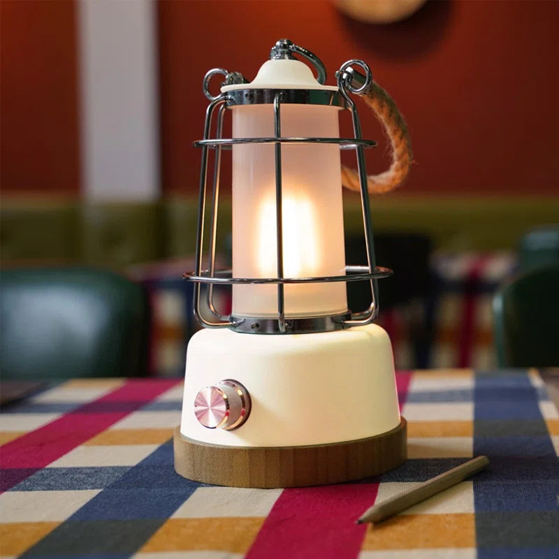 Retro camping lantern with warm glow, metal cage, wooden base, perfect for van life and outdoor adventures