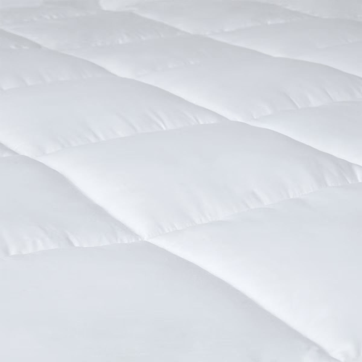 White quilted van mattress topper for cozy camper van sleep