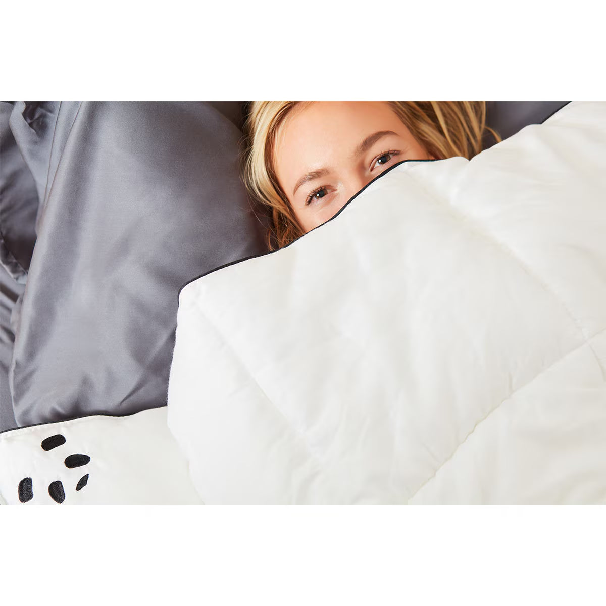 Cozy white quilted van life blanket with black trim, perfect for camper van bedding and outdoor adventures.