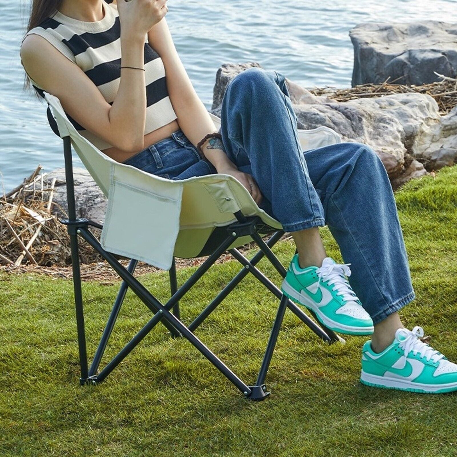 Portable camping chair by lake, perfect for van life and outdoor adventures