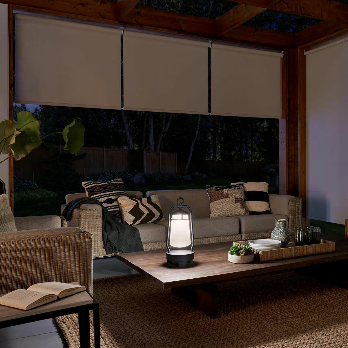 Cozy outdoor patio with lit lantern, wicker sofa, and blackout blinds for van life or backyard relaxation