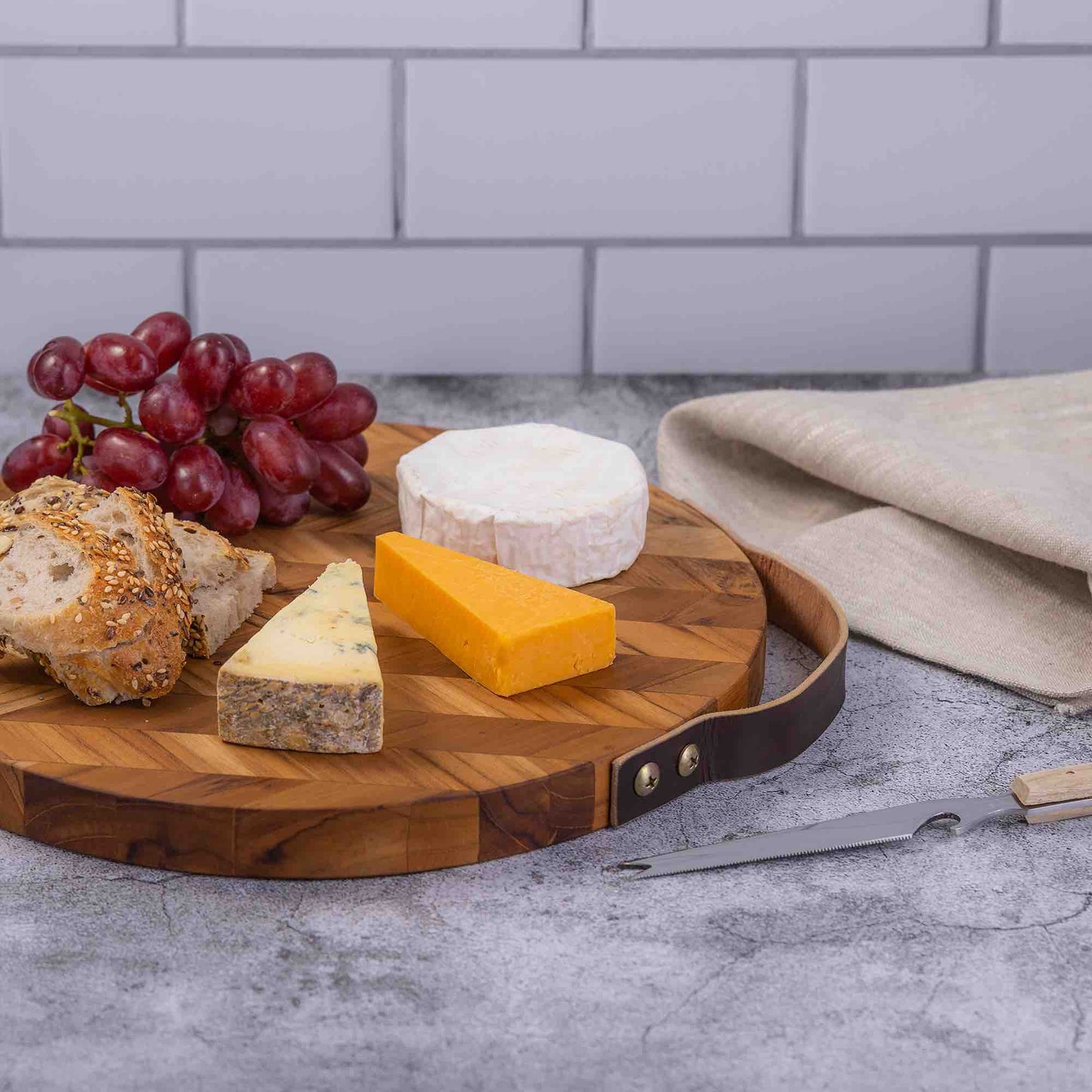 Wooden cheese board with assorted cheeses, grapes, and bread for van life picnics and outdoor adventures