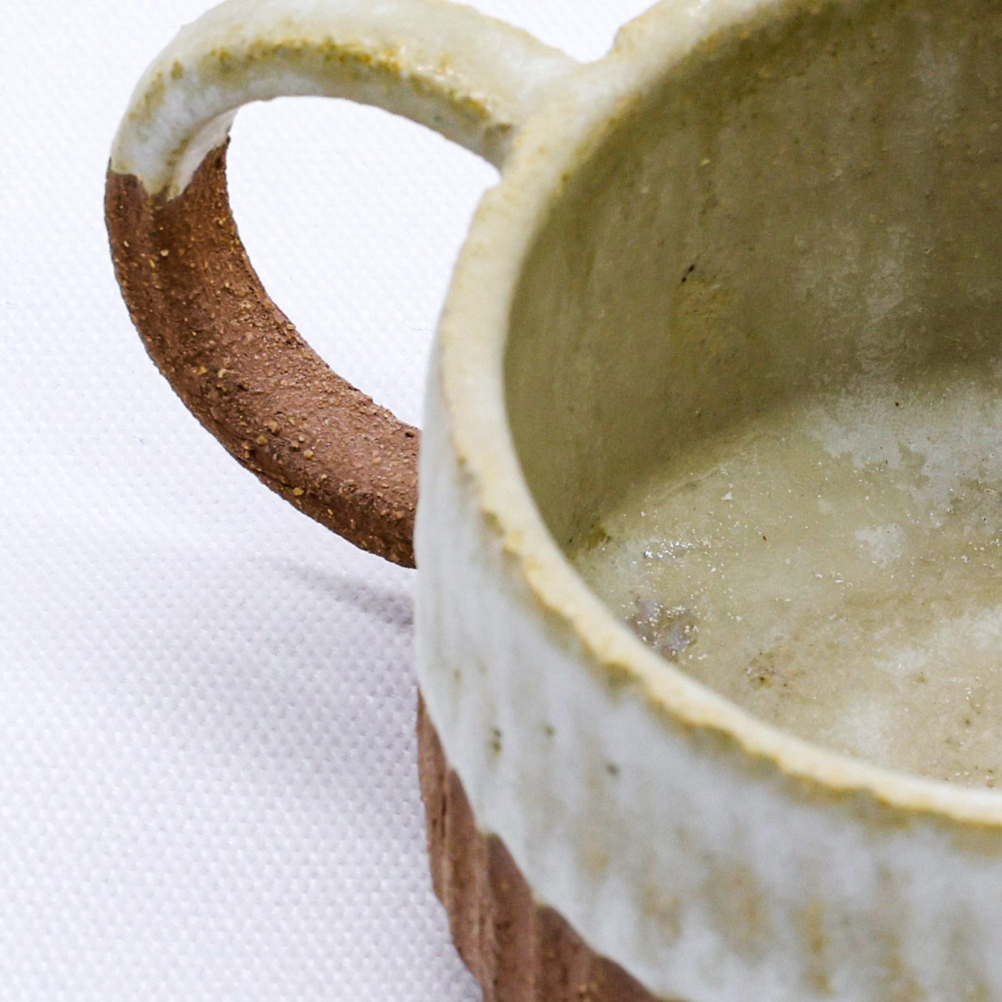 Handmade ceramic mug with rustic handle, perfect for van life adventures and outdoor camping gear essentials.