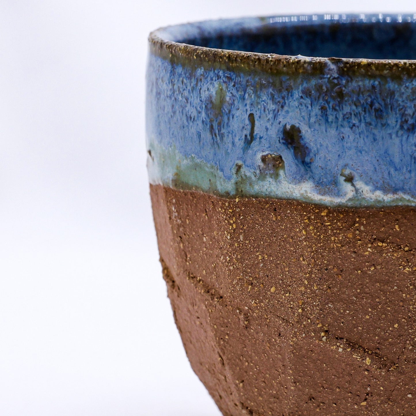 Handmade ceramic mug with blue glaze and rustic brown base, perfect for van life adventures