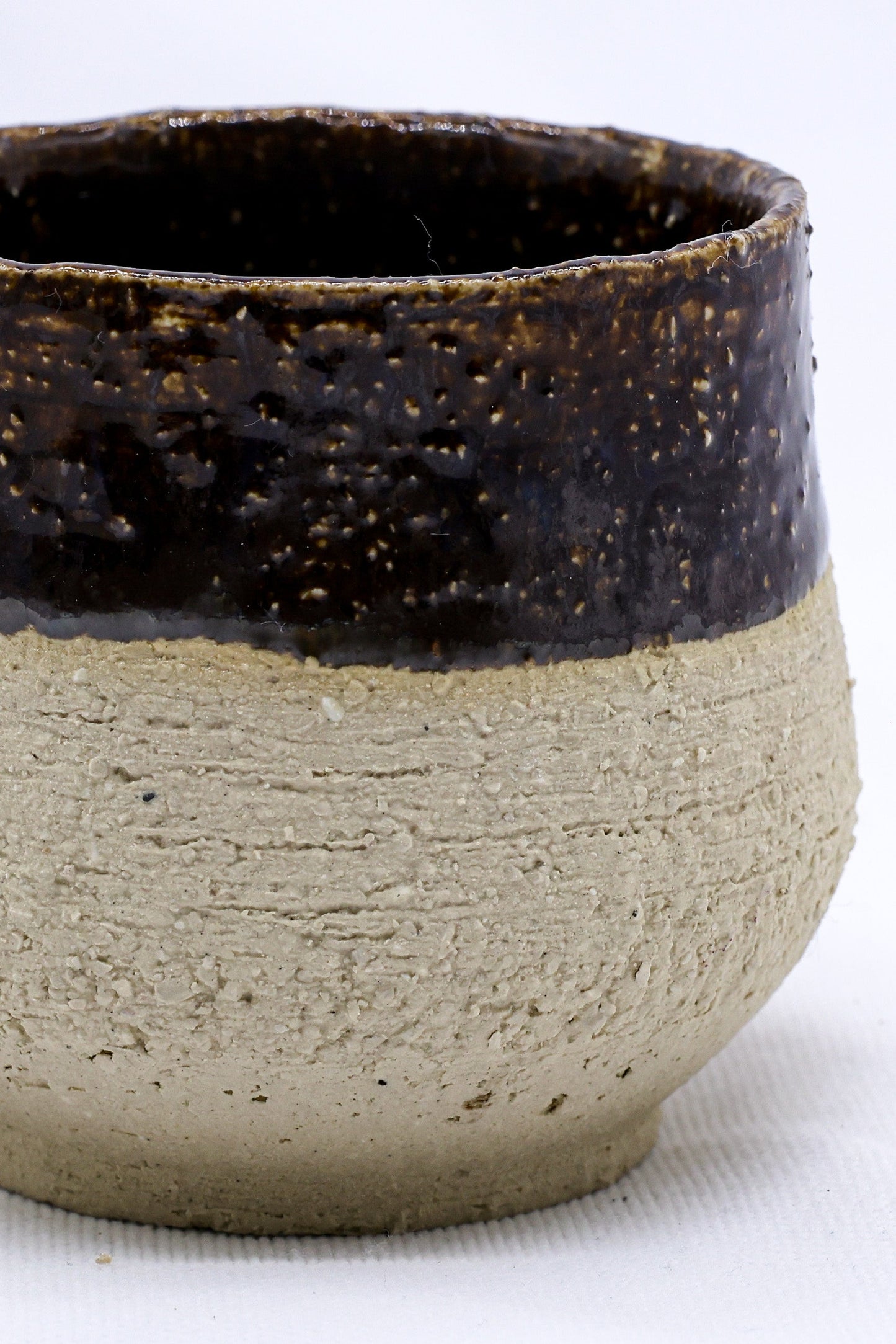 Handmade ceramic mug with rustic brown glaze, perfect for van life adventures and outdoor camping.