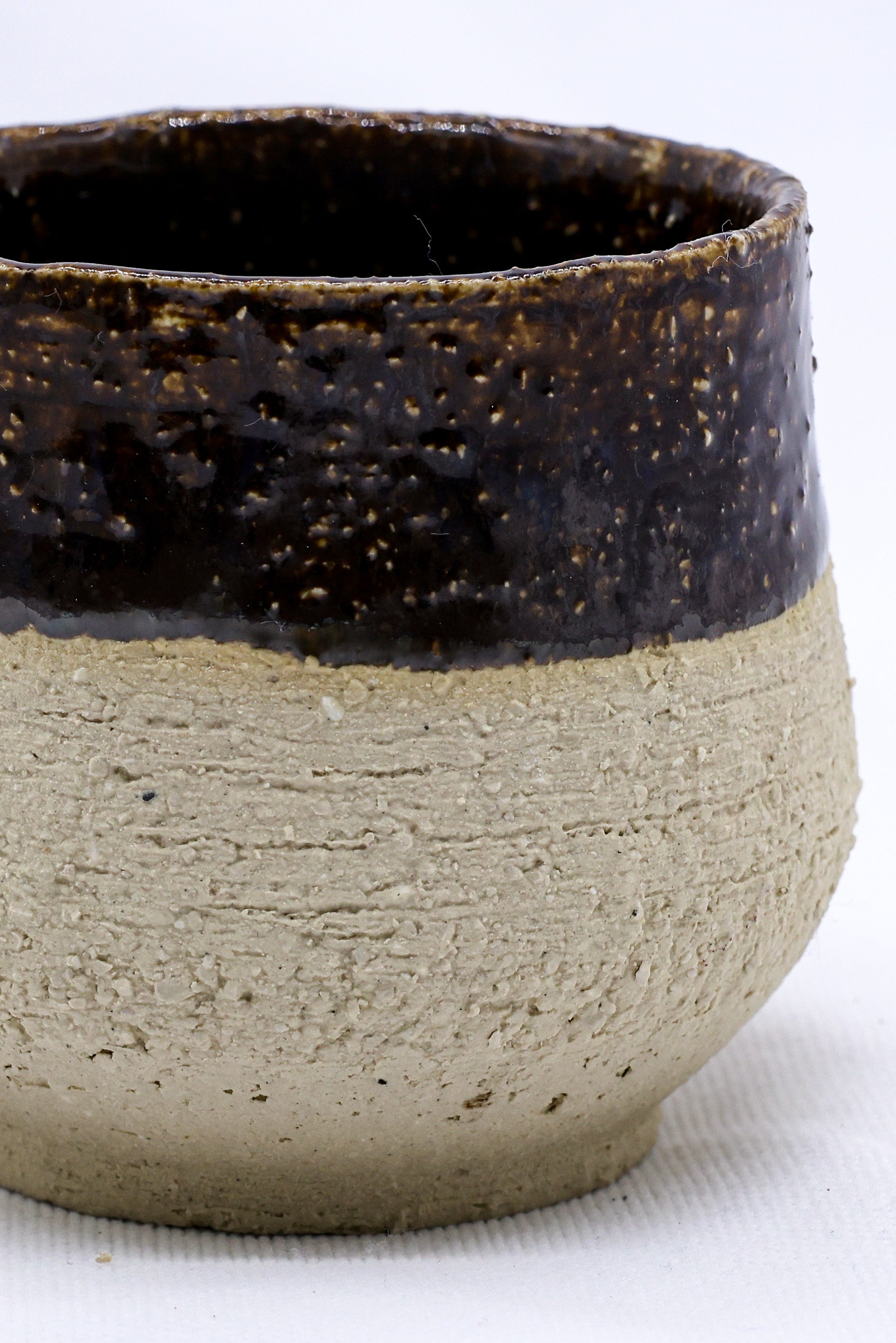 Handmade ceramic mug with rustic brown glaze, perfect for van life adventures and outdoor camping.