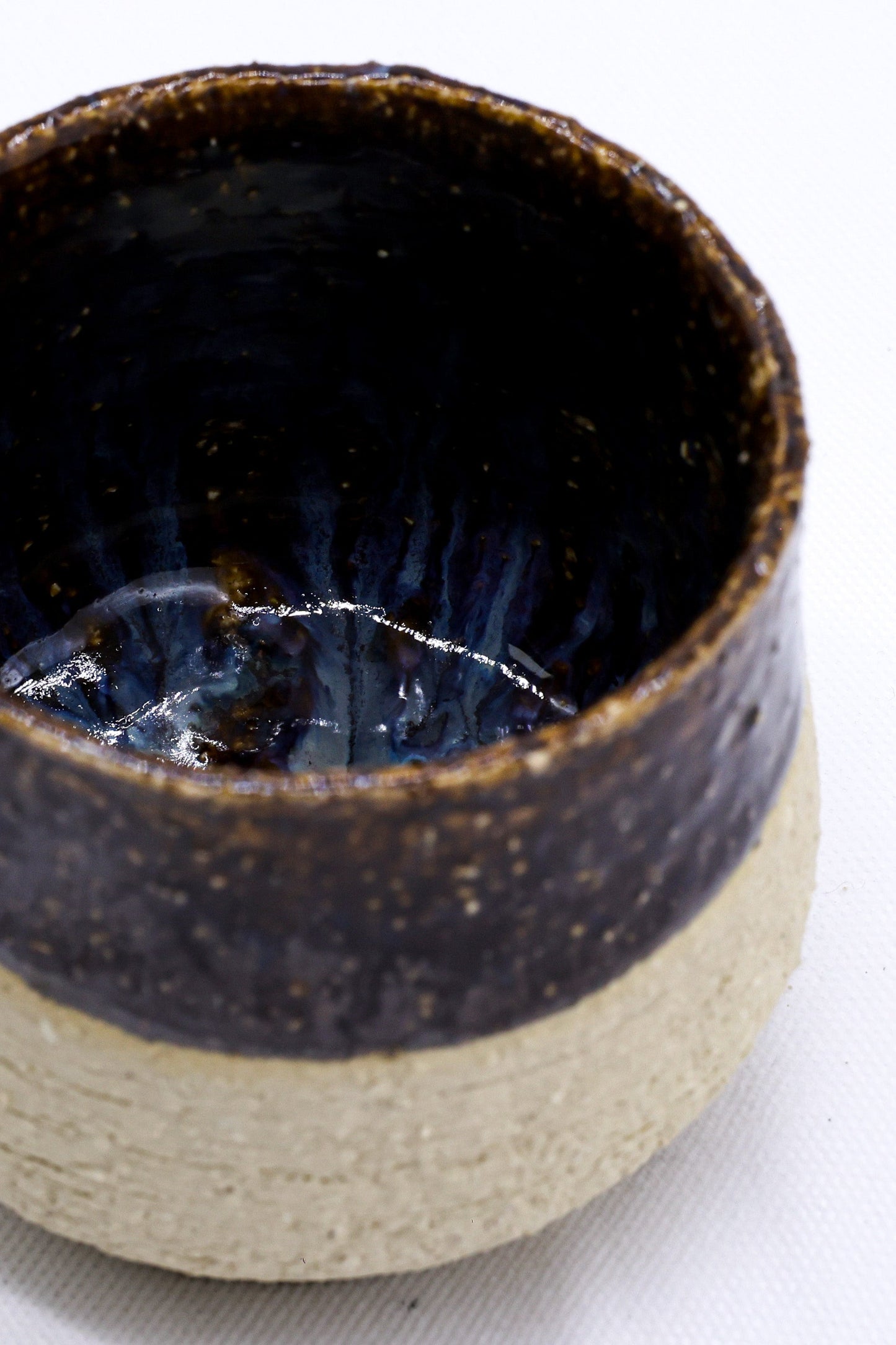 Handcrafted ceramic mug with dark glaze, perfect for van life adventures and outdoor camping gear essentials.