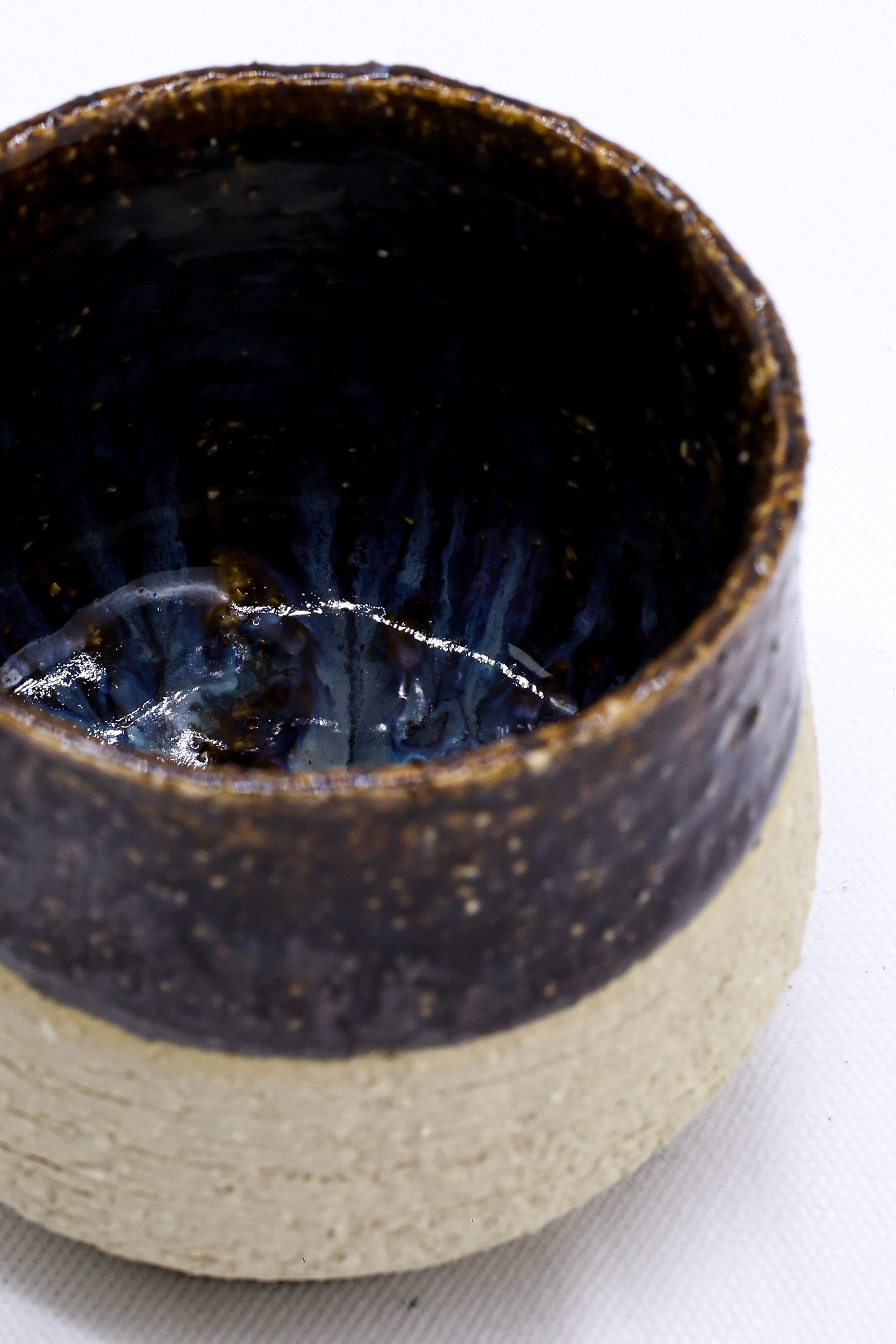 Handcrafted ceramic mug with dark glaze, perfect for van life adventures and outdoor camping gear essentials.