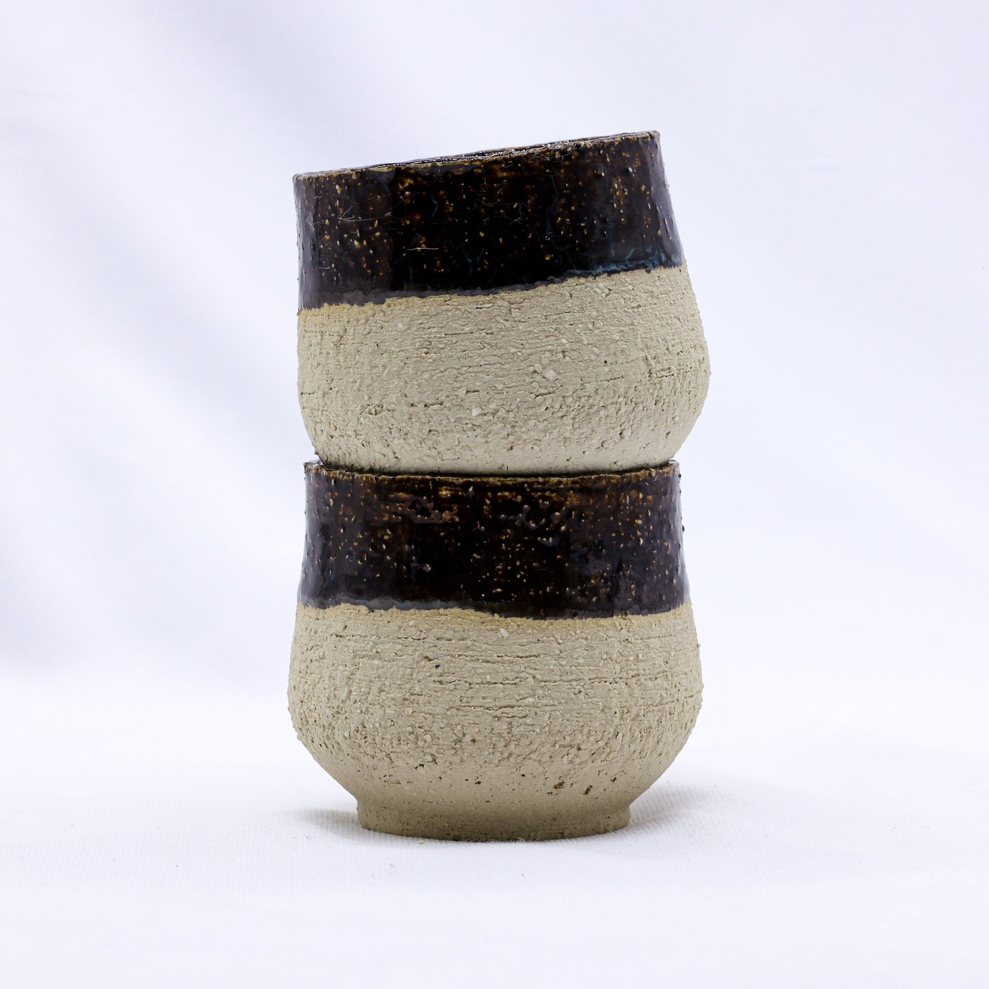 Handcrafted ceramic cups with rustic brown glaze, perfect for van life essentials and outdoor adventures.