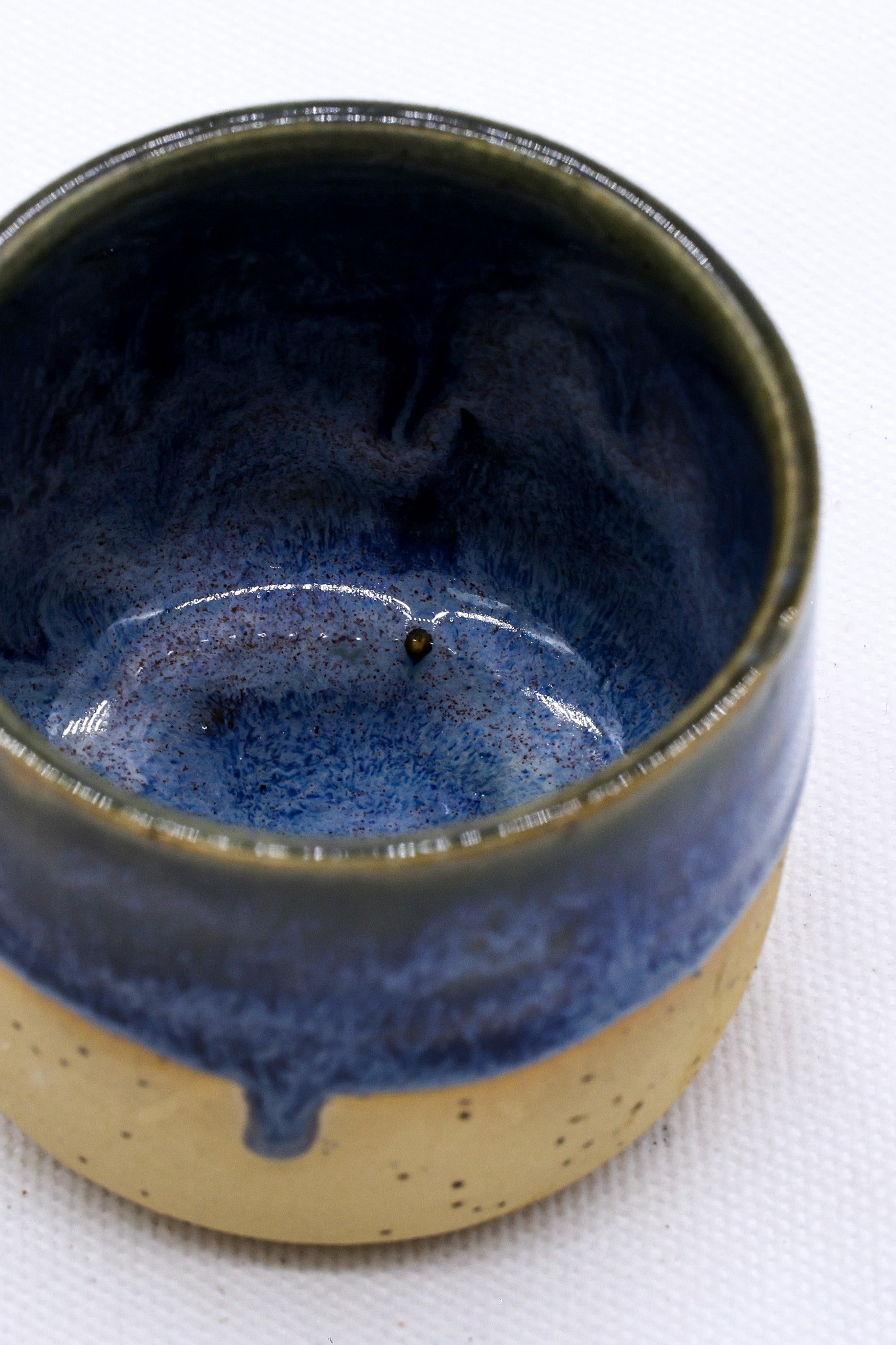 Handmade ceramic mug with blue glaze drip, perfect for van life adventures and outdoor camping gear essentials.