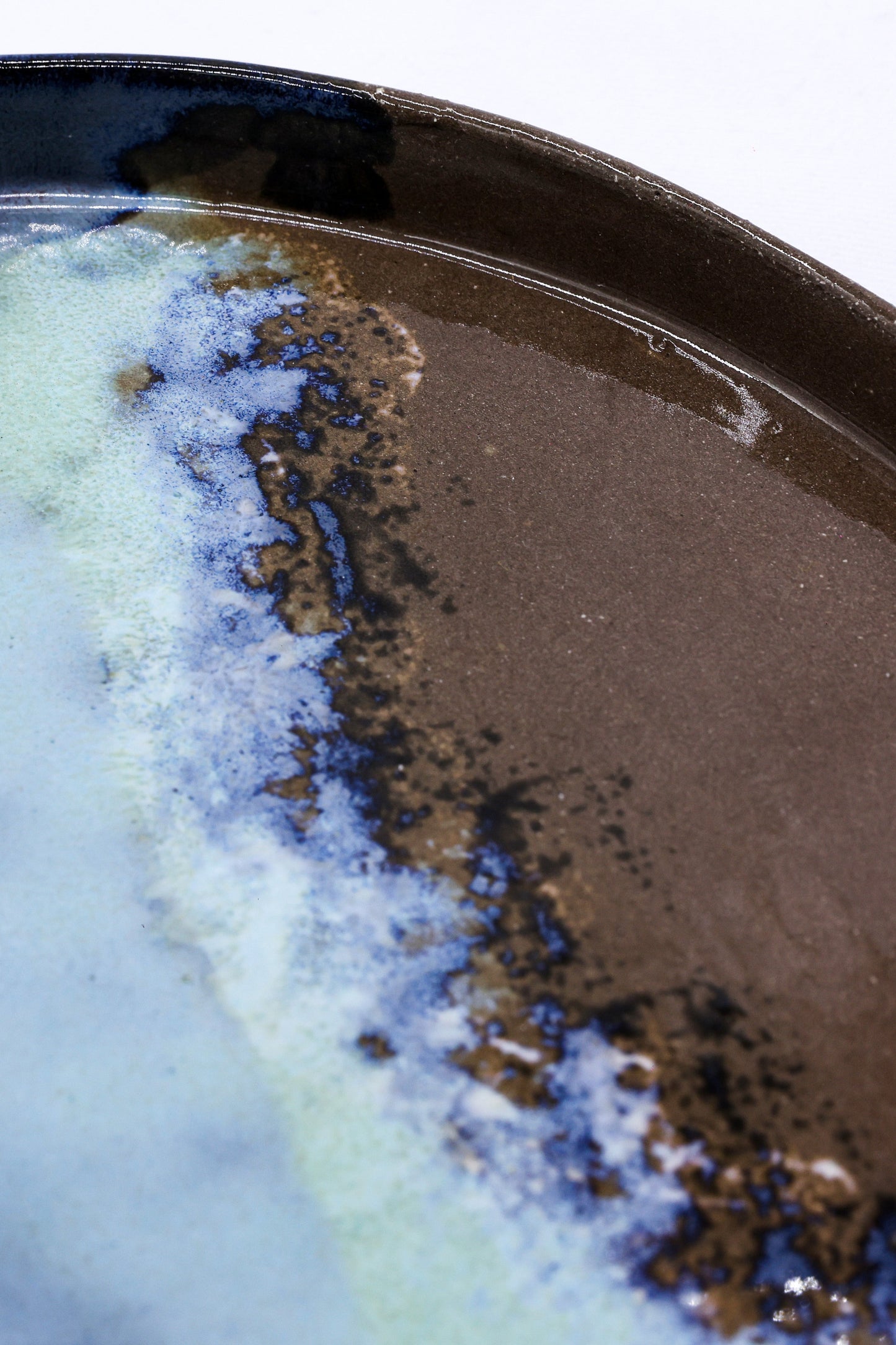 Handcrafted ceramic plate with rustic blue and brown glaze, perfect for van life dining