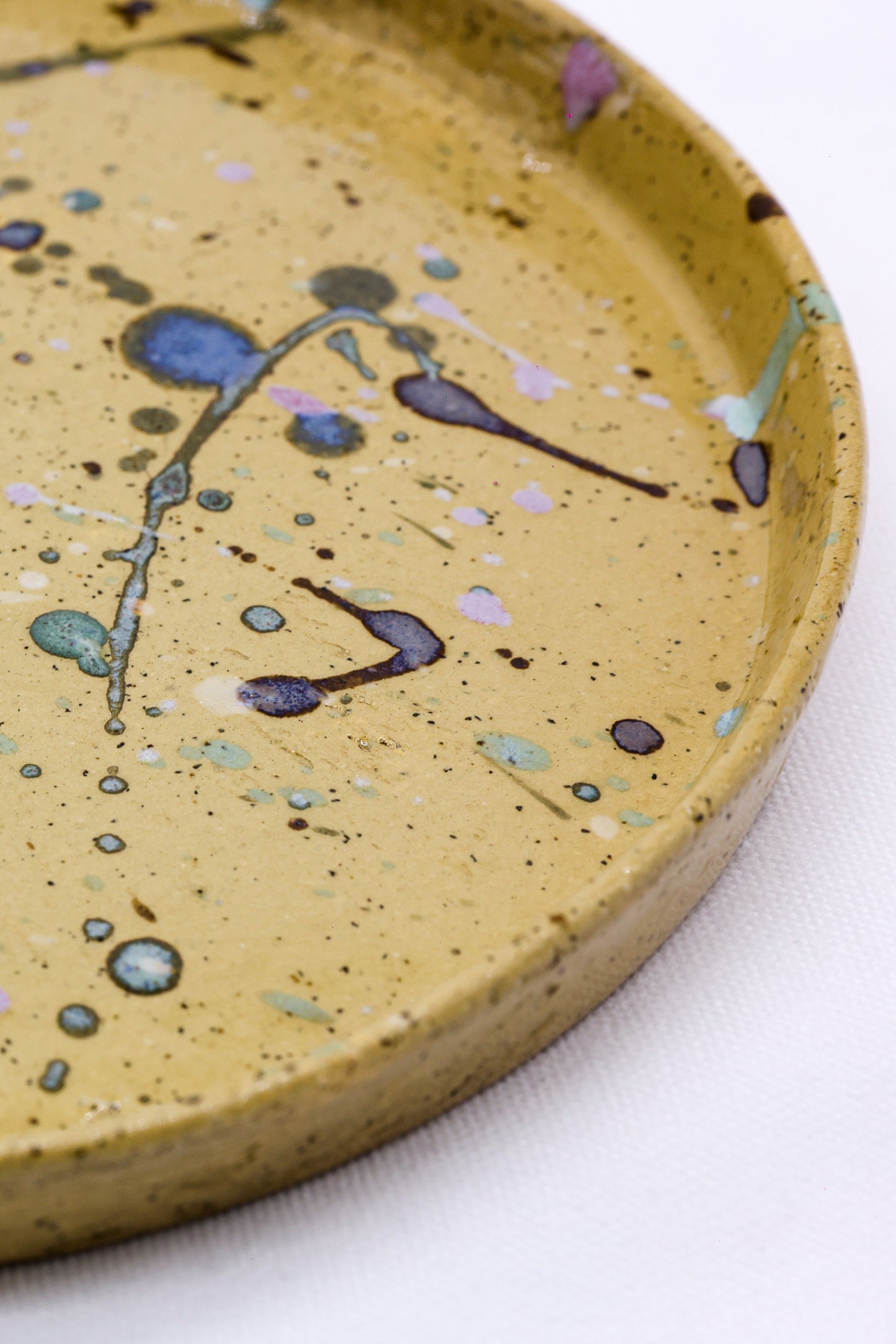 Handcrafted ceramic tray with speckled mustard glaze and abstract floral design, perfect for van life essentials.