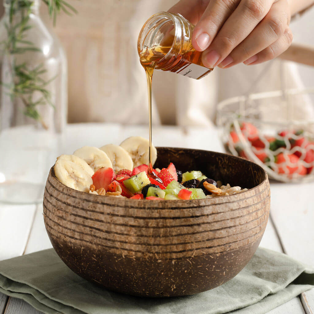 Coconut bowl with fresh fruit salad and honey drizzle, perfect for van life breakfasts and outdoor adventures