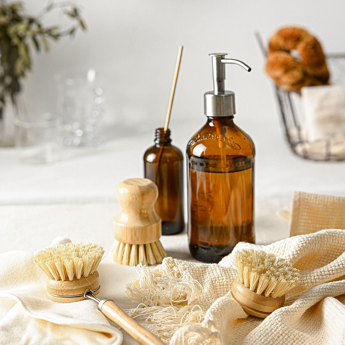 Eco-friendly van life cleaning kit with wooden brushes, amber glass soap dispenser, and natural fiber cloths