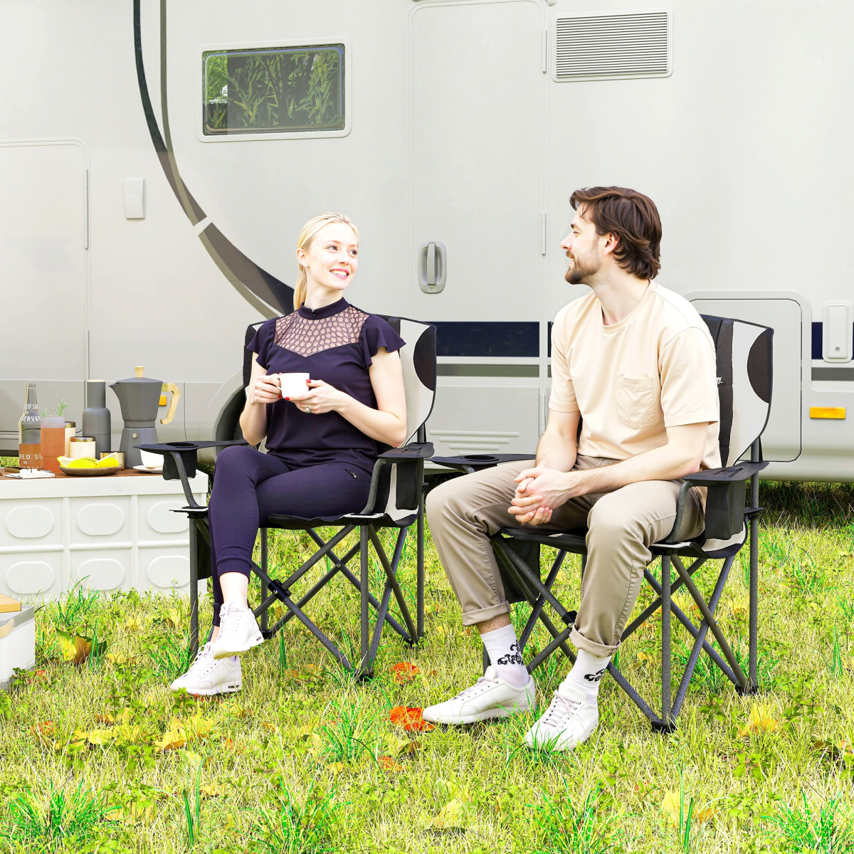 Couple relaxing in portable camping chairs outside camper van, enjoying coffee and outdoor adventure gear