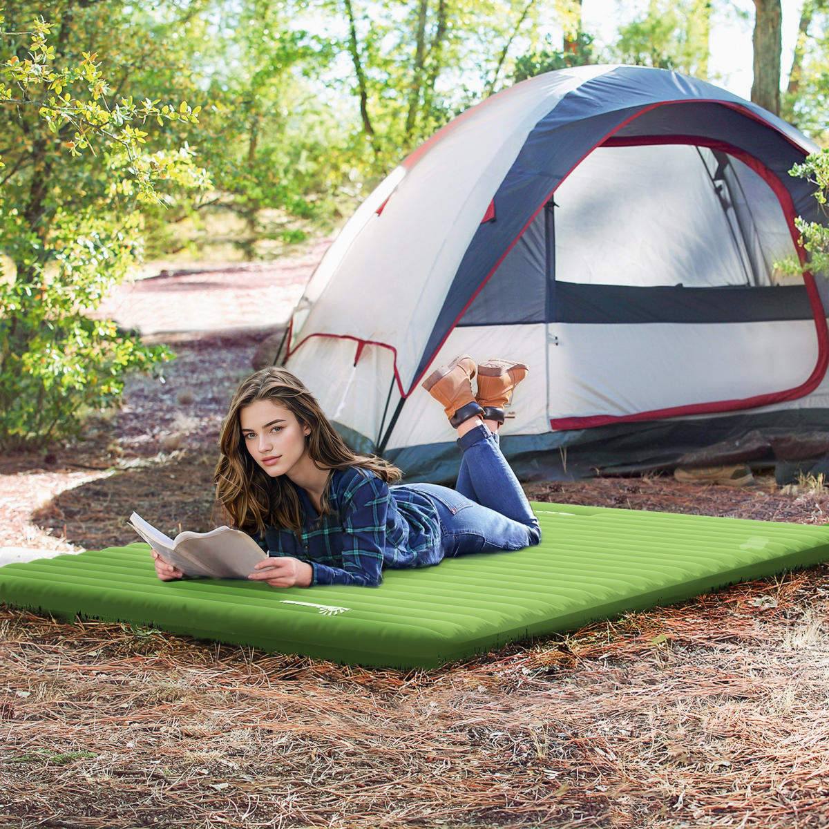 Woman relaxing on green camping mattress outdoors near tent, perfect for van life and outdoor adventures