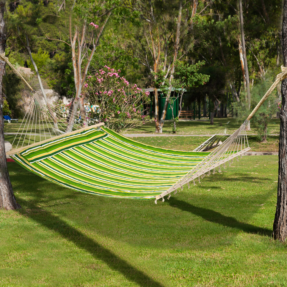 Green striped hammock for outdoor relaxation in garden or campsite, perfect for van life adventures