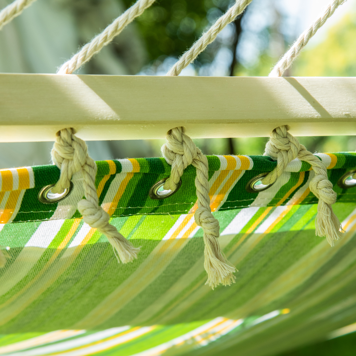 Green and yellow striped hammock with rope ties, perfect for van life adventures and outdoor relaxation.