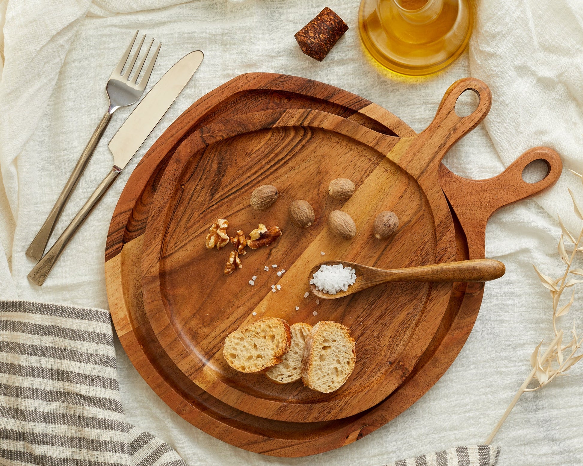 Wooden serving boards with bread, nuts, salt, and olive oil for van life kitchen essentials