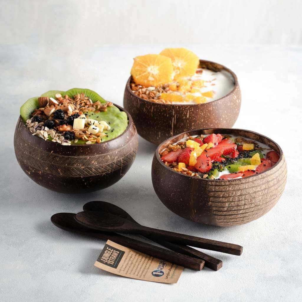 Coconut bowls with smoothie bowls, granola, fresh fruit & wooden spoons — perfect for van life meals