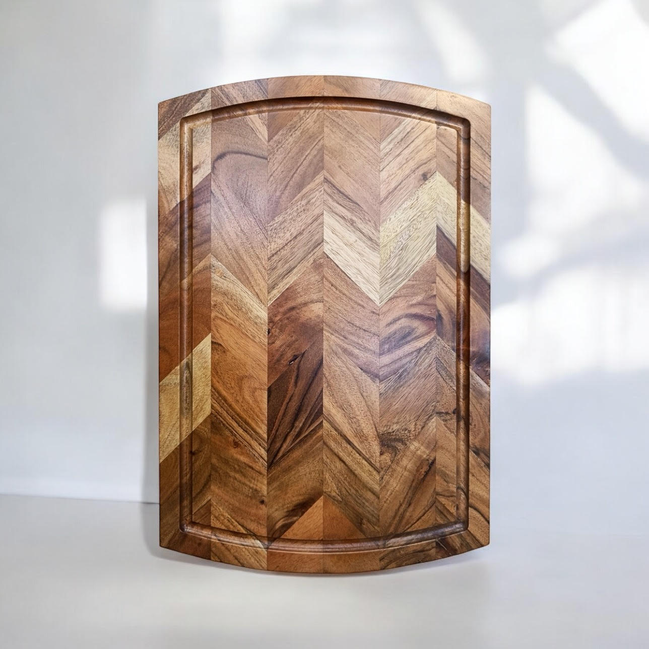 Wooden cutting board with chevron pattern, ideal for van life kitchen essentials and outdoor cooking gear.
