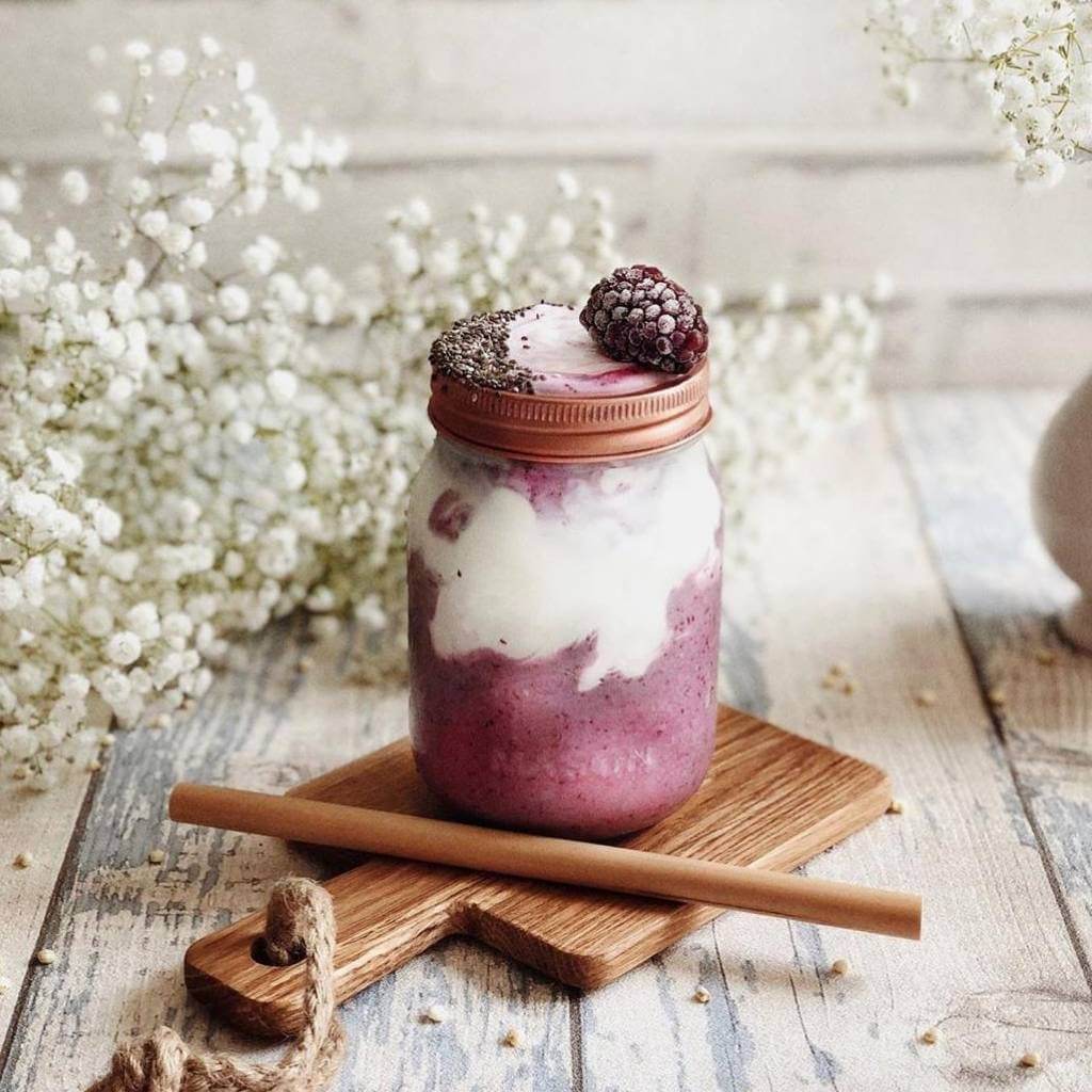 Berry smoothie in mason jar with chia seeds and wooden straw, perfect for van life adventures