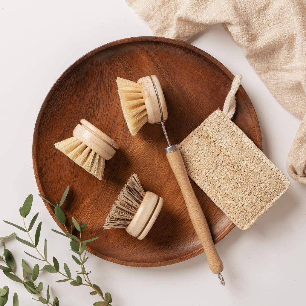 Eco-friendly wooden dish brushes and natural sponge on wooden tray for van life kitchen essentials