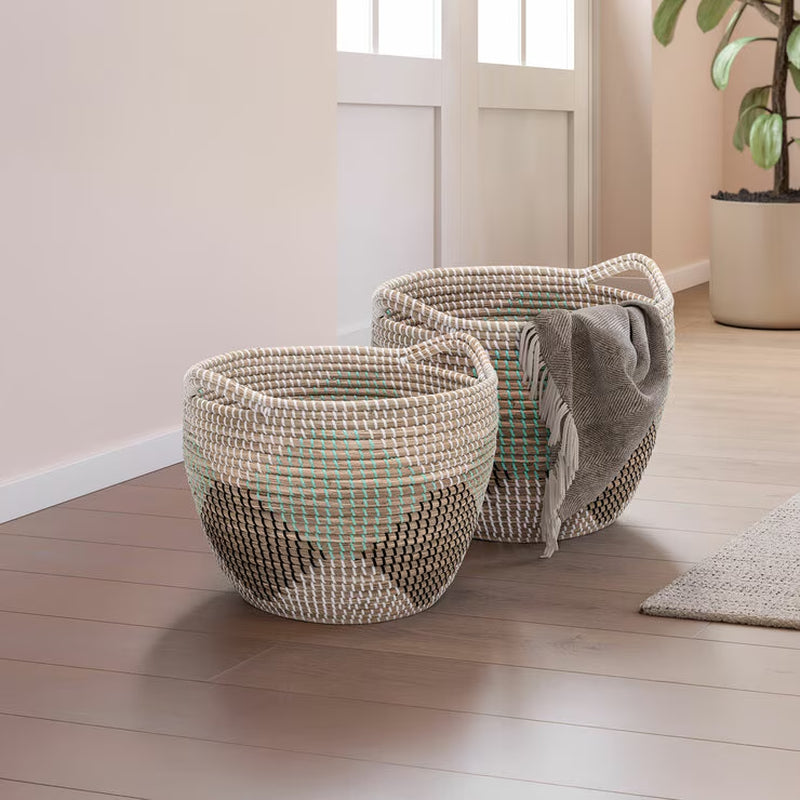Round Seagrass Storage Baskets – Set of 2 – two baskets holding a blanket in a room