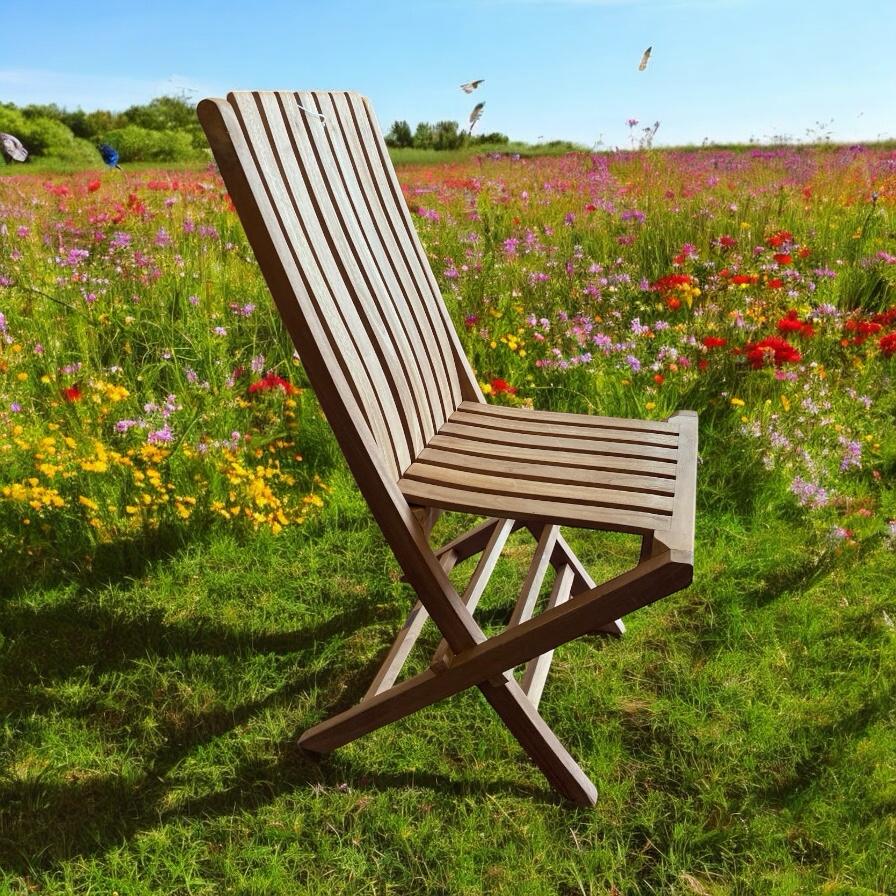 Foldable wooden camping chair in vibrant wildflower meadow, perfect for van life adventures and outdoor relaxation