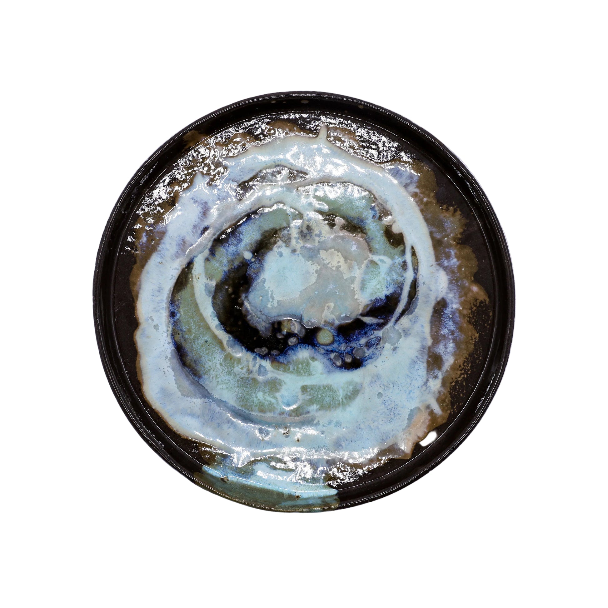 Handcrafted ceramic plate with swirling blue, white, and brown glaze, perfect for van life dining essentials.