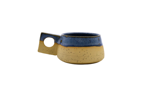 Handmade ceramic mug with blue glaze and speckled tan base, perfect for van life adventures