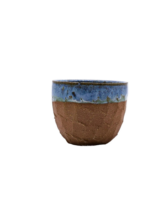 Handmade ceramic cup with blue glaze, perfect for van life adventures and outdoor camping gear.