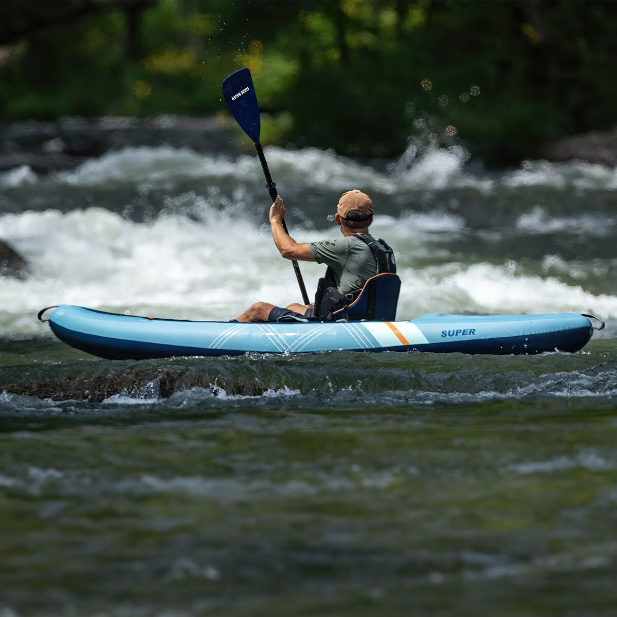 Man kayaking in blue inflatable kayak on river rapids, perfect for outdoor adventure gear and van life essentials