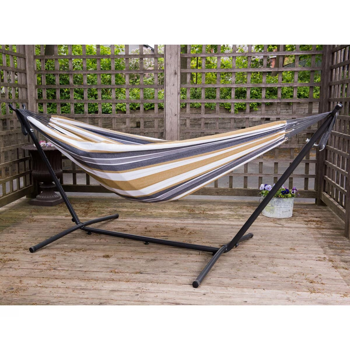 Striped hammock with stand on wooden deck, perfect for van life relaxation and outdoor adventures