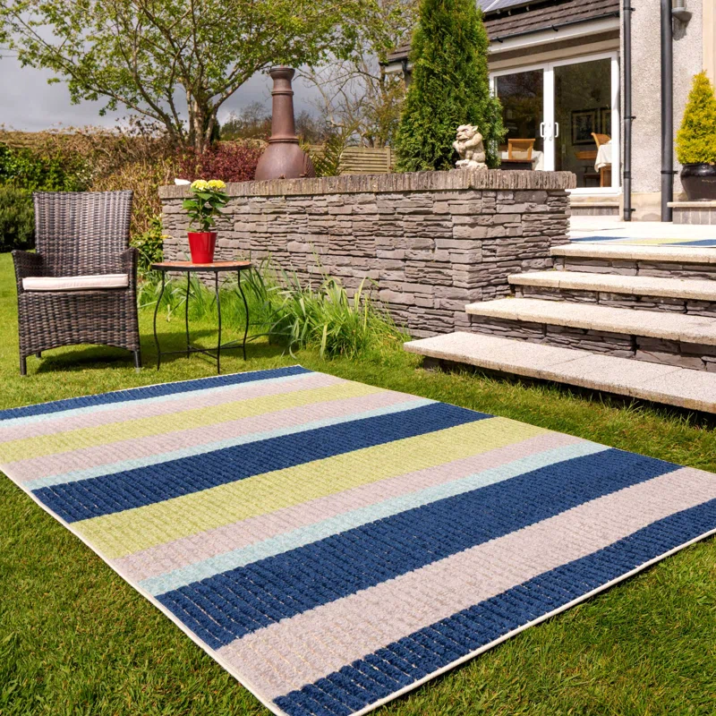 Striped outdoor rug on grass, perfect for van life patios or garden lounging