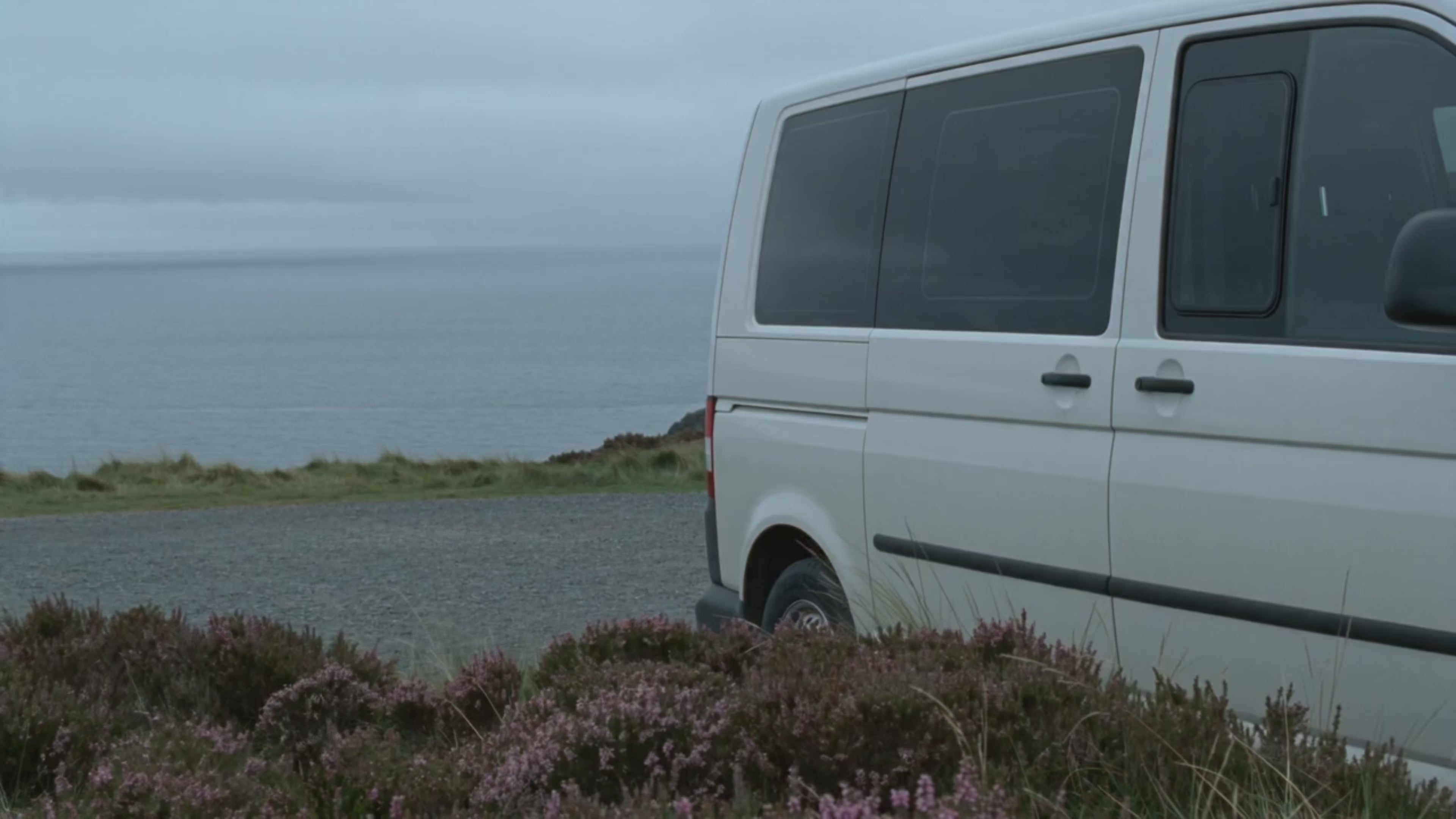 Load video: Campervan travelling through rugged UK coastal landscapes in moody grey weather, capturing the freedom of van life, scenic road trips, remote countryside adventures and slow travel across Britain’s wild coastline.