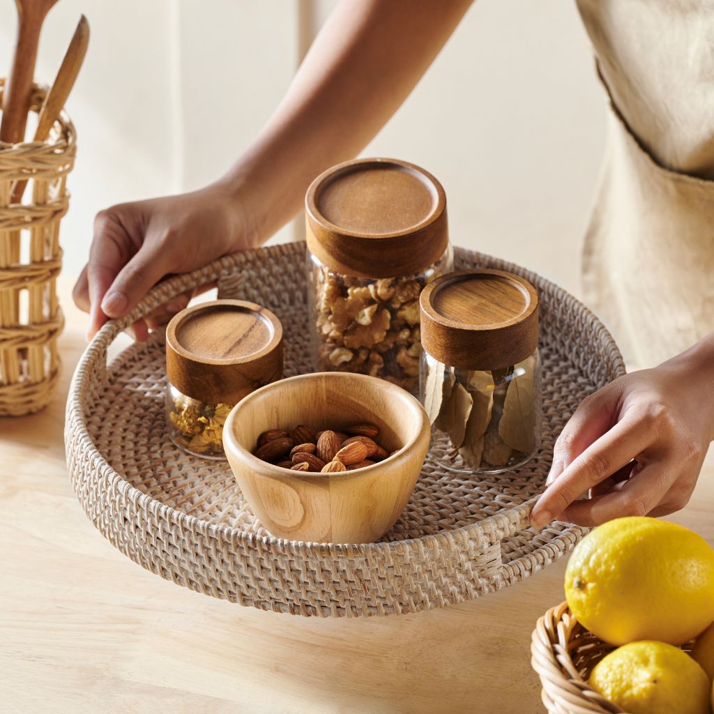 Woven tray with wooden bowls, glass jars, and nuts — perfect for van life kitchen storage and organization