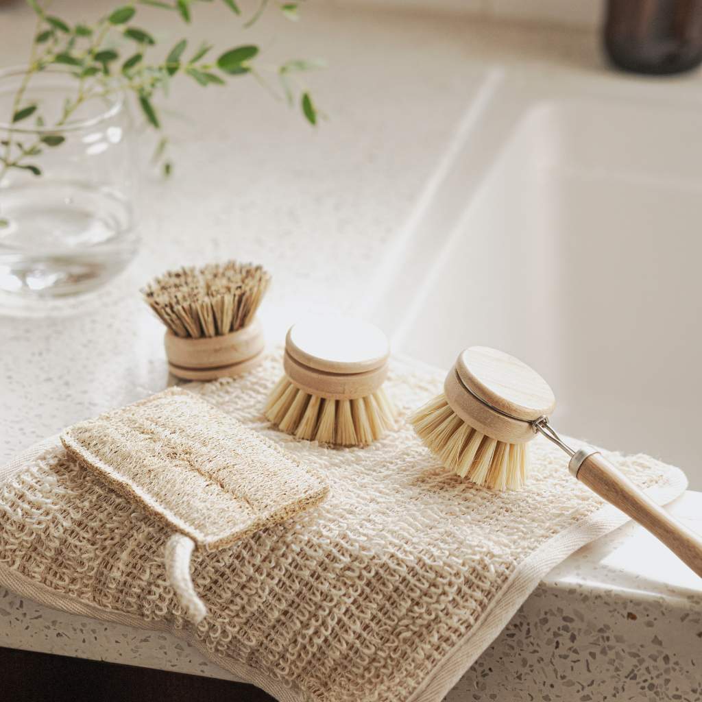 Eco-friendly wooden dish brushes and natural fiber scrub pads for van life kitchen cleaning