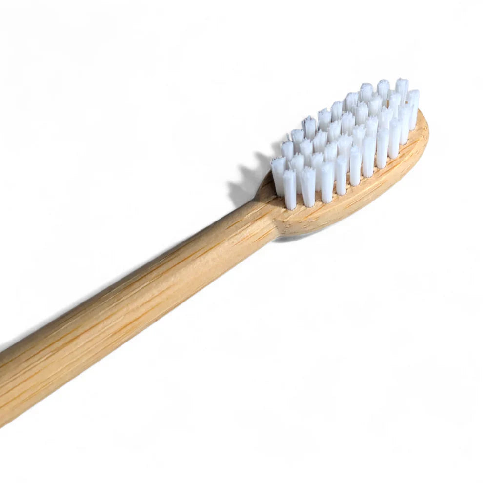 Bamboo toothbrush with white bristles for eco-friendly van life essentials