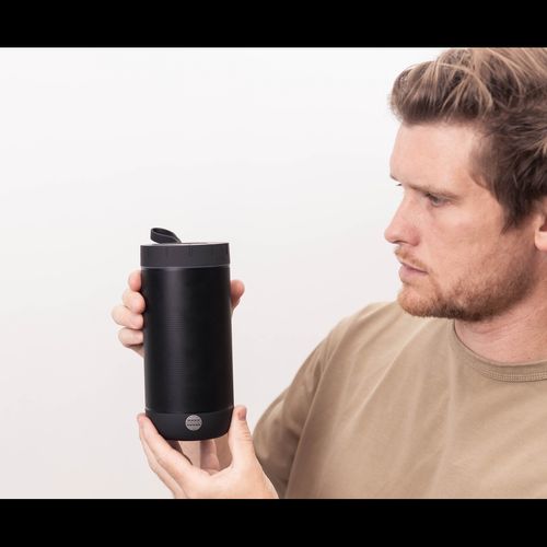 Man holding black insulated travel mug for van life adventures and outdoor use