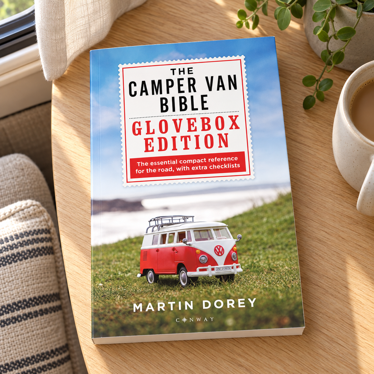 The Camper Van Bible: The Glovebox Edition – book on a wooden campervan table
