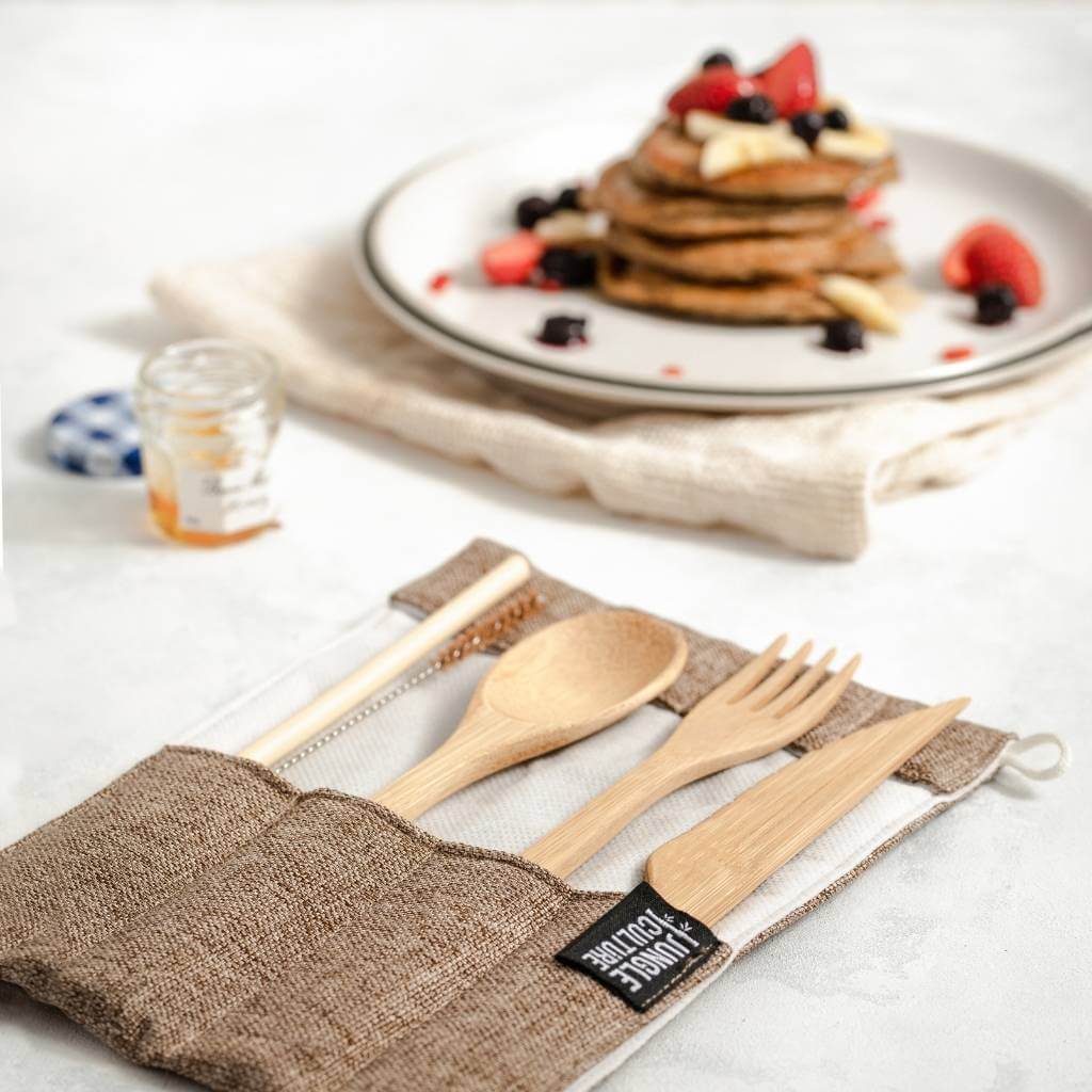 Bamboo cutlery set in eco-friendly pouch with pancakes and berries, perfect for van life and outdoor adventures